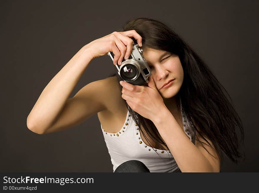 Fashion girl posing with camera isolated on black background. Fashion girl posing with camera isolated on black background