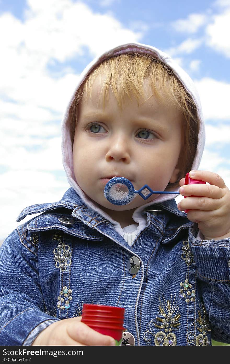 Cute little girl making soap bubbles