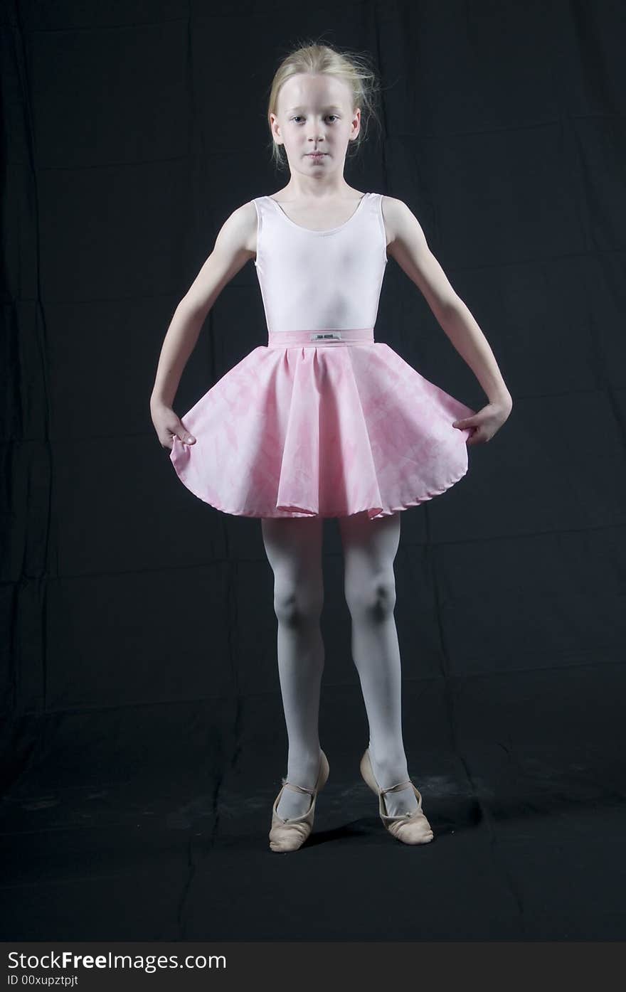 Young blond girl with blue eyes aspiring to be a ballet dancer practices her jump and claps. Young blond girl with blue eyes aspiring to be a ballet dancer practices her jump and claps