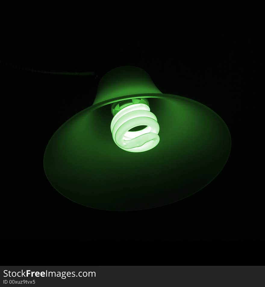 Go green with energy saving light bulbs! A dark picture with the just the energy saving light bulb in a lamp illuminating the sides. Go green with energy saving light bulbs! A dark picture with the just the energy saving light bulb in a lamp illuminating the sides.