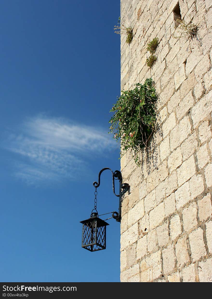 Retro antern on old stone wall with blue sky. Retro antern on old stone wall with blue sky