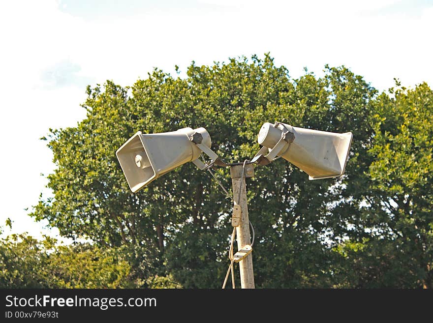 A public address system against a treenand sky background. A public address system against a treenand sky background