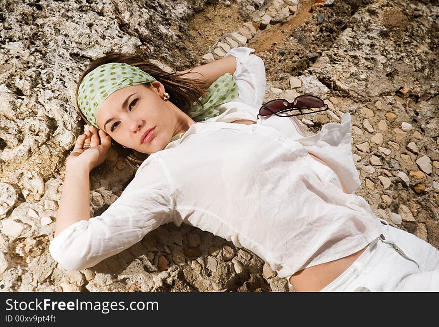 Portrait of fashion female lying on rock background. Portrait of fashion female lying on rock background