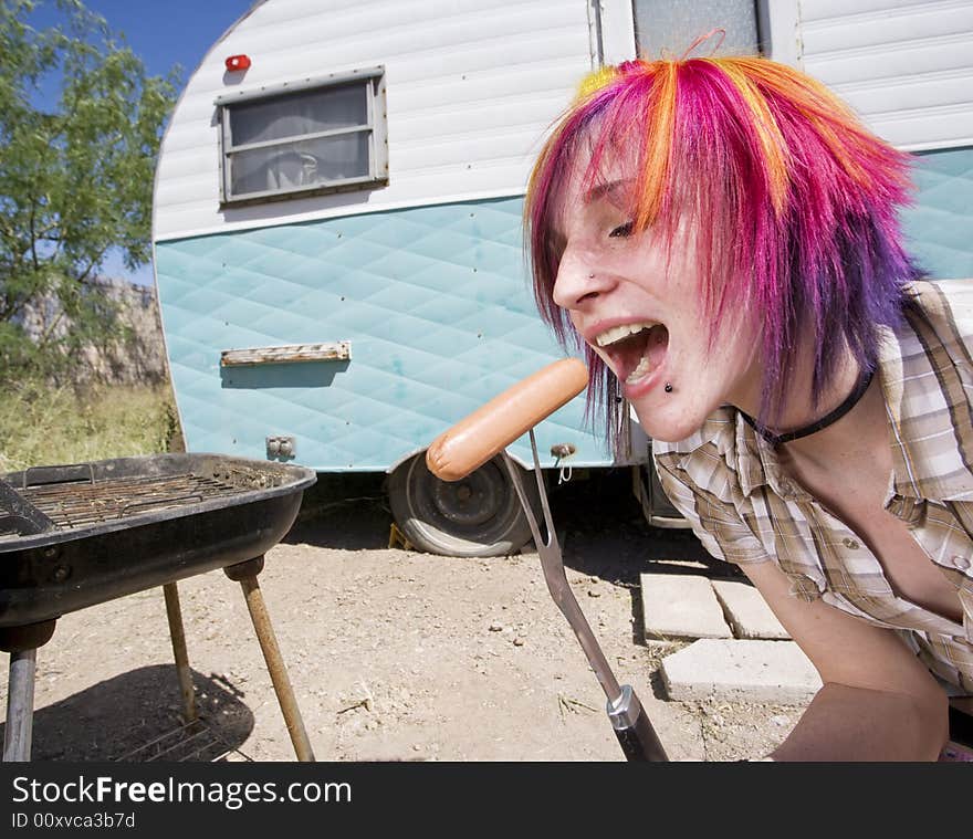 Girl in front of a trailer eating a hotdog