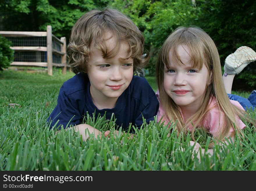 Two four year old laying in the grass. Two four year old laying in the grass