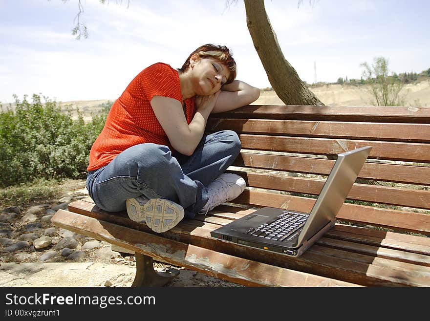 A young woman using a portable computer outside. A young woman using a portable computer outside