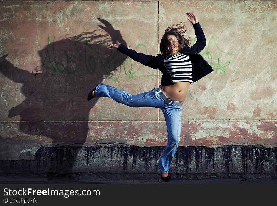 Young cute girl jumping against the wall. Young cute girl jumping against the wall.