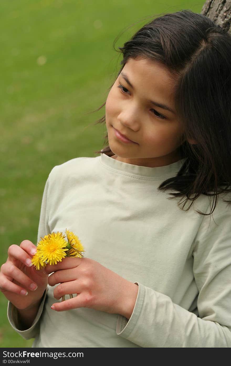 Girl holding dandelions with sad expression