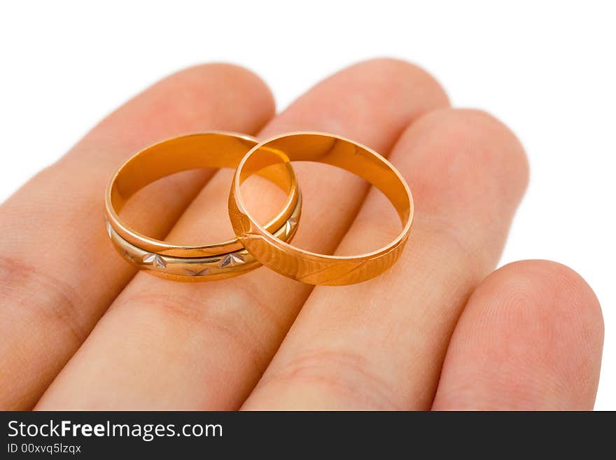 Wedding gold rings on hand isolated on white background