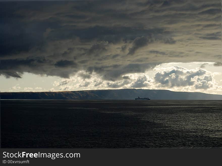 Storm clouds gather over a ship at sea. Storm clouds gather over a ship at sea.