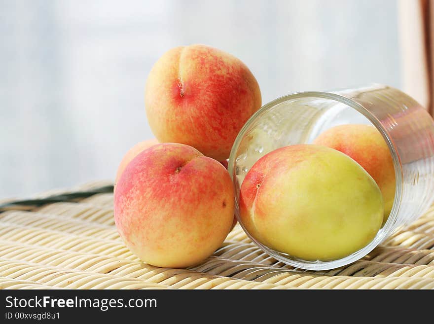 The fresh peach with white background on a cane chair. The fresh peach with white background on a cane chair