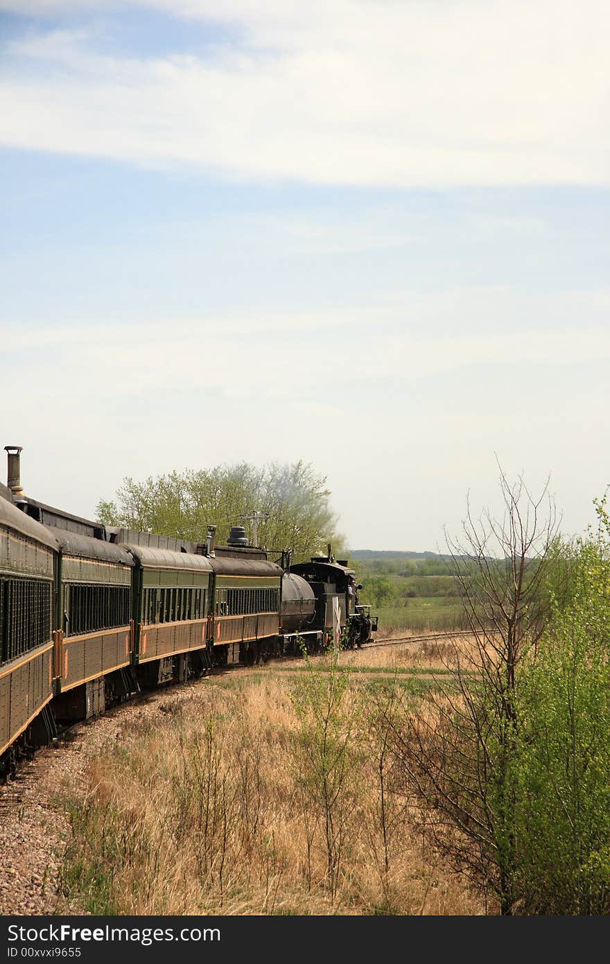 A restored Steam Engine pulling passenger cars through the Canadian Prairies. A restored Steam Engine pulling passenger cars through the Canadian Prairies