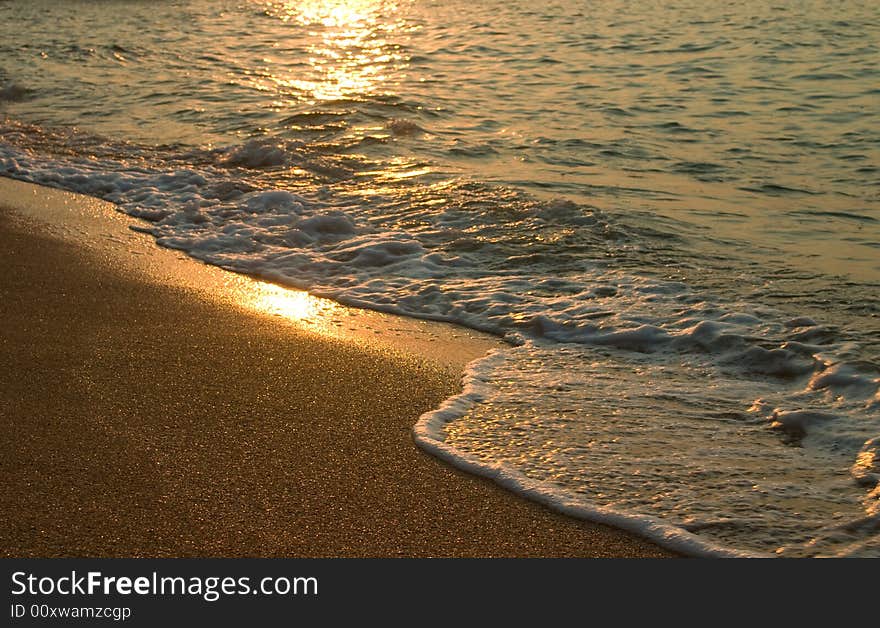 Sunset and sea surf on sand beach. Sunset and sea surf on sand beach