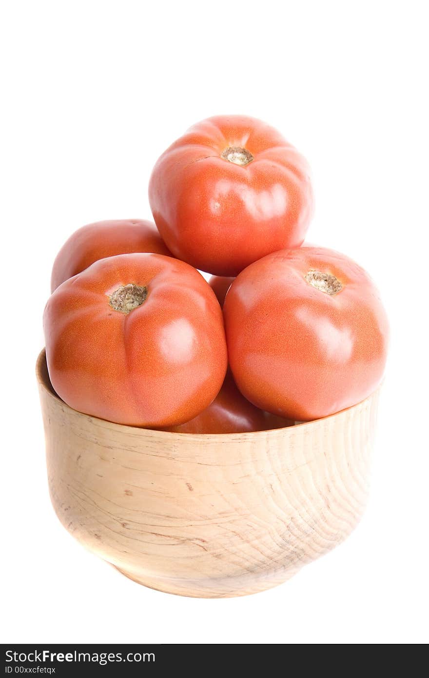 Fresh ripe red tomatoes in a wooden bowl on a white background. Fresh ripe red tomatoes in a wooden bowl on a white background