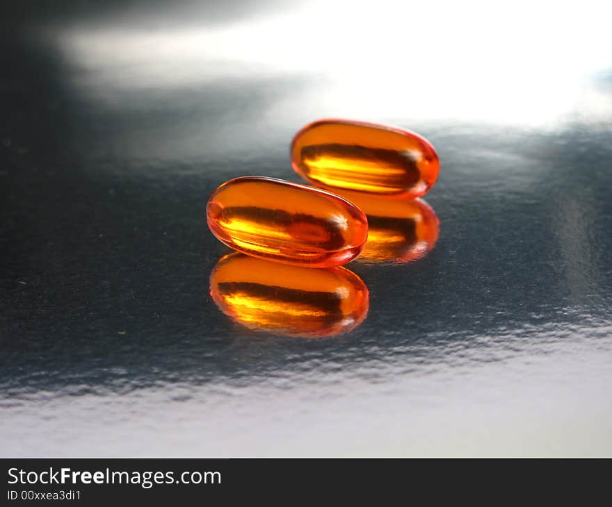 Gelatin capsules in a silver background