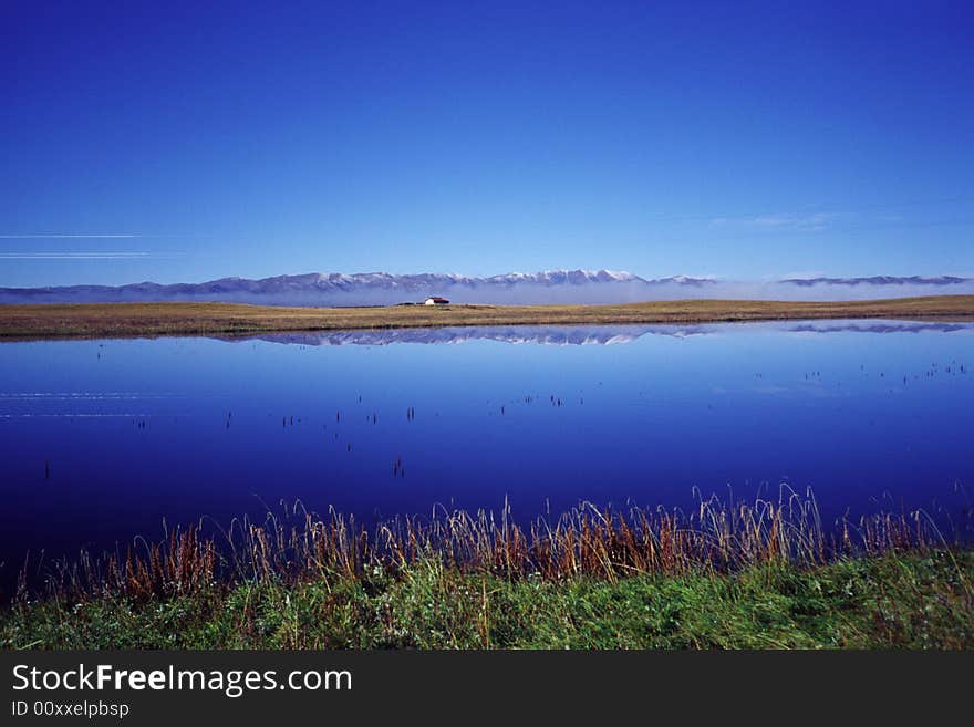 A peaceful blue lake with mountains and sky - in gansu province, china