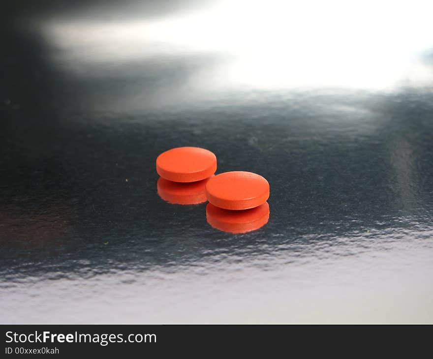 Orange medicines in a silver background