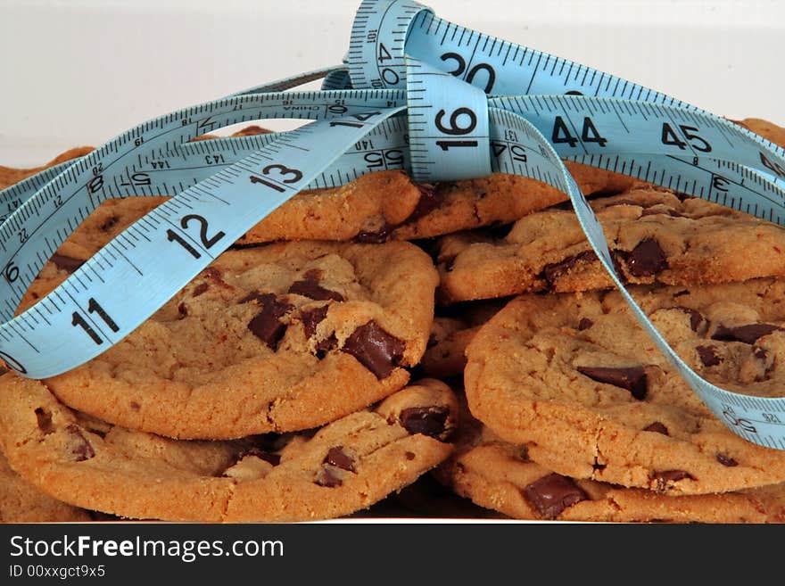 Chocolate chip cookies tied in a bow with a tape measure. Chocolate chip cookies tied in a bow with a tape measure