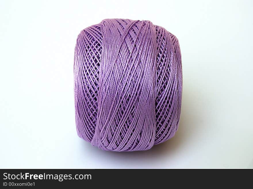 Close up lilac yarn ball for handicraft projects like crochet and knitting.