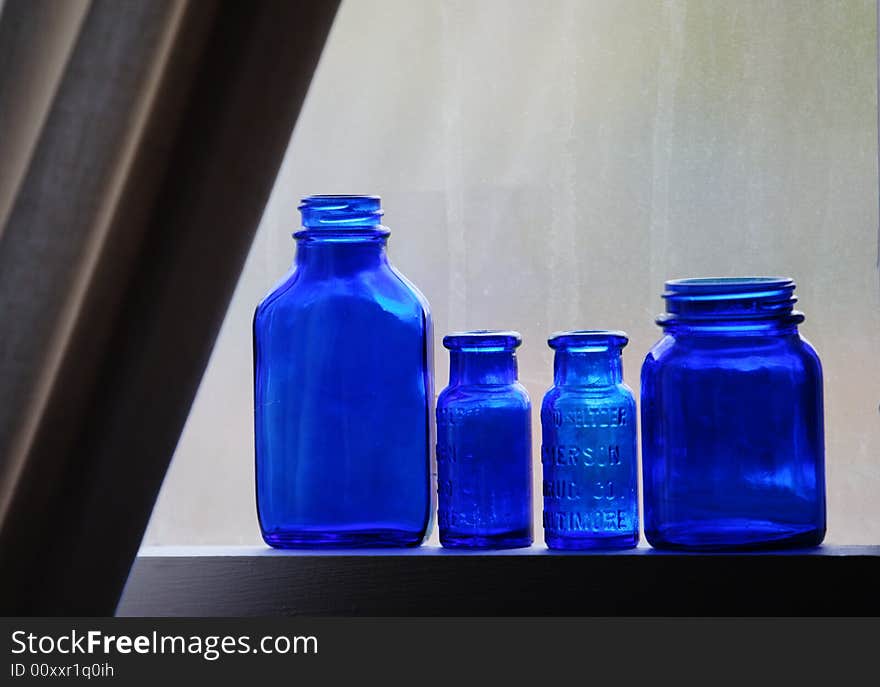 Old blue medicine bottles on window sill. Old blue medicine bottles on window sill