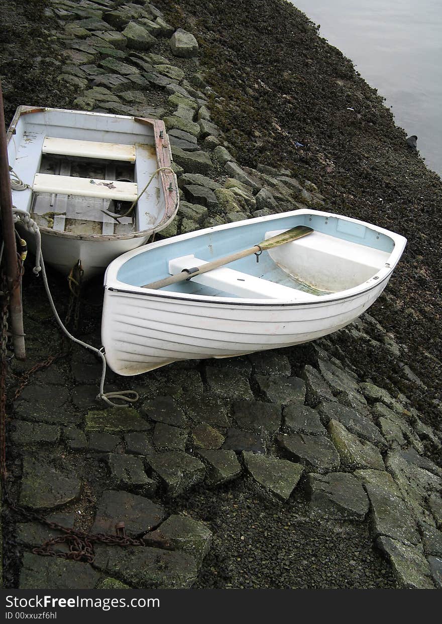 Two small boats on the side of the river