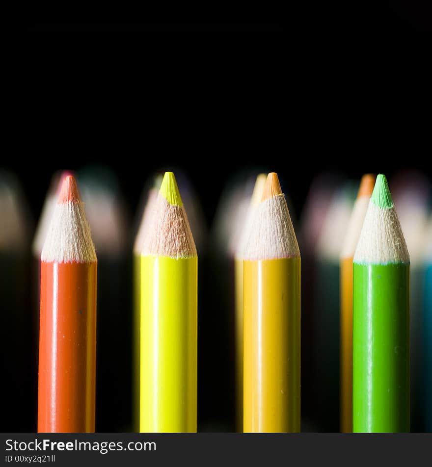 Rows of Bright colored pencils against black background