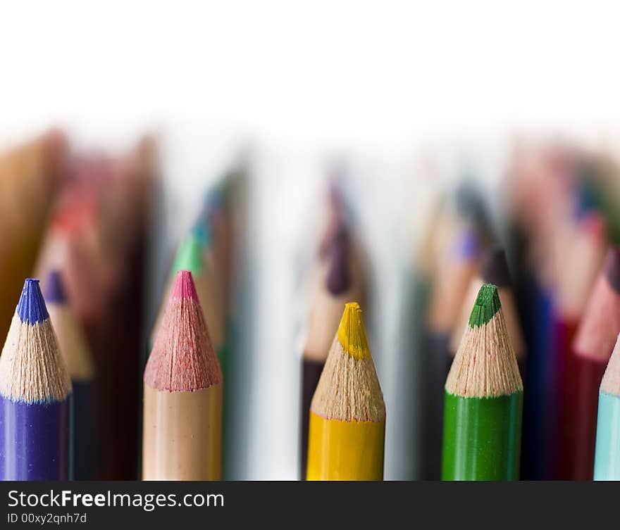 Rows of Bright colored pencils against white background