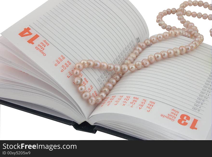 Open diary and pearl beads as a bookmark. Open diary and pearl beads as a bookmark