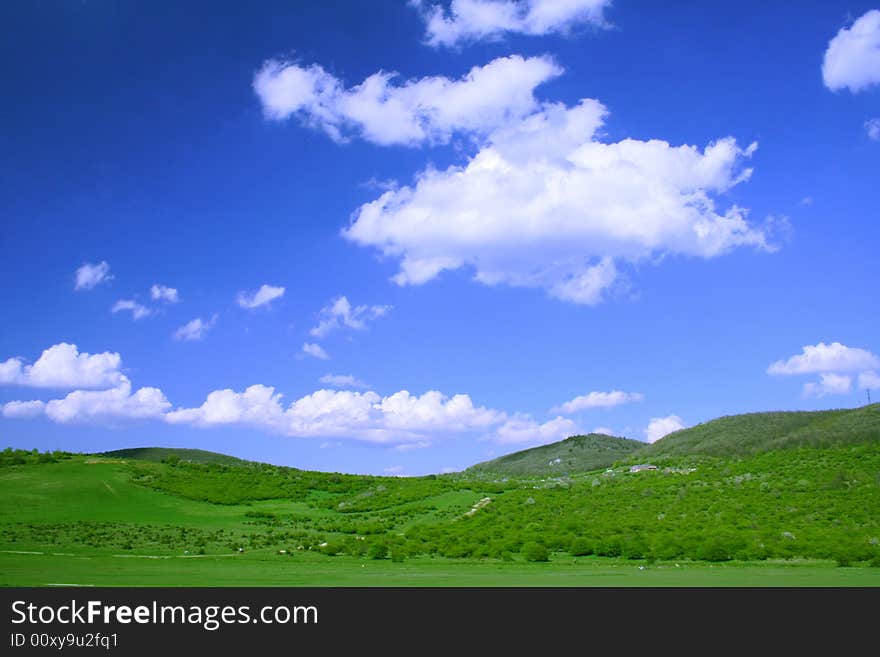 Green field and hills with blue sky and clouds. Green field and hills with blue sky and clouds