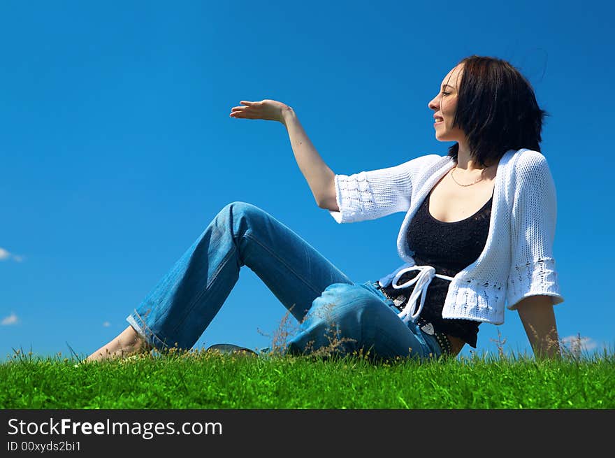 Woman sit in green field un hold hand palm up