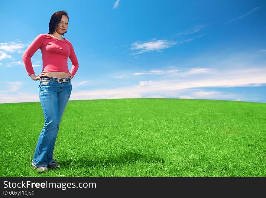 Woman in field with blue sky and clouds