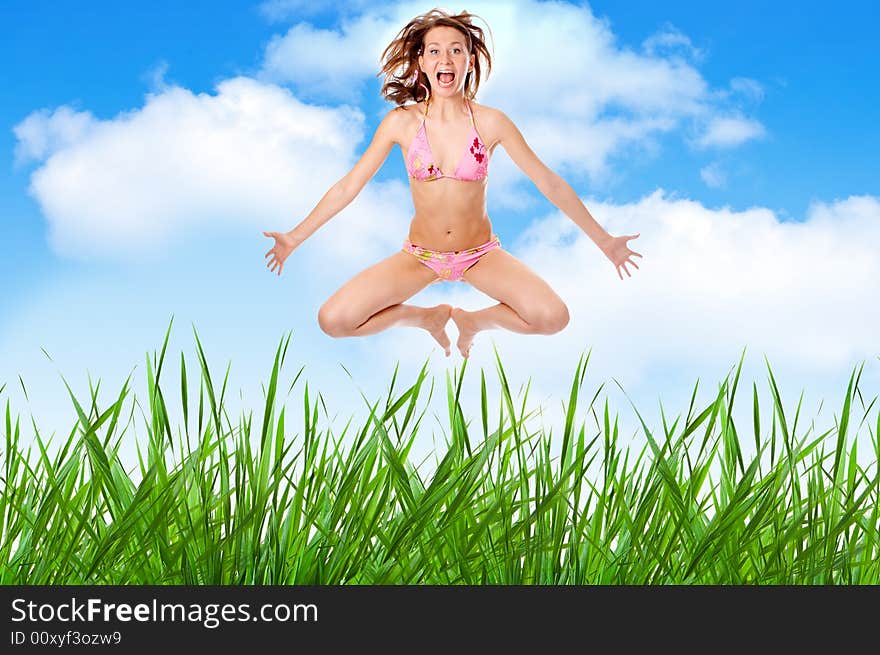 Woman in lingerie jump over grass under blue sky with clouds