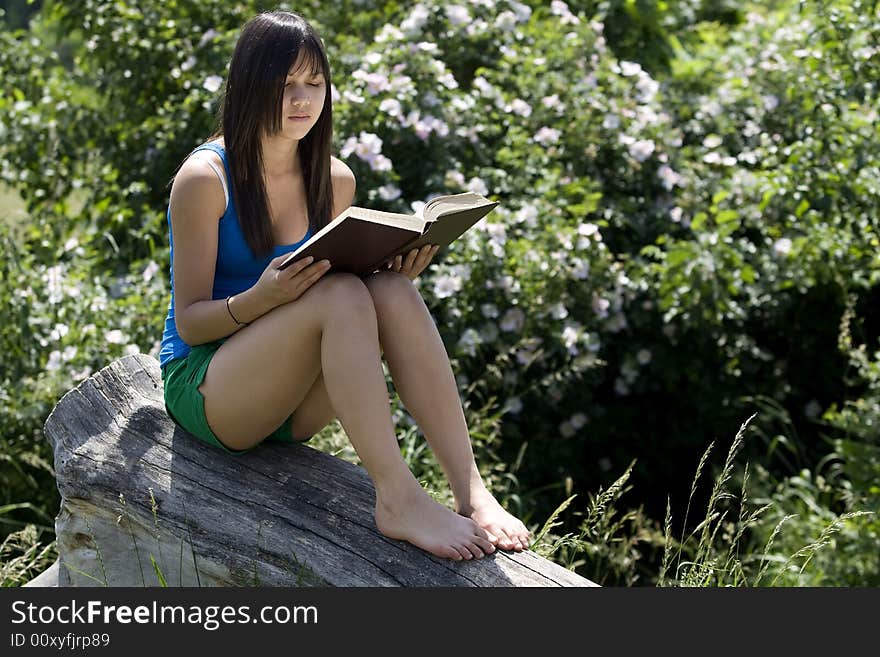 Teenager read a book in nature at an excursion