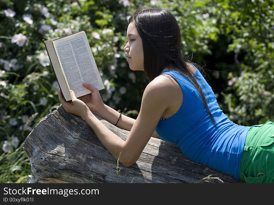 Teenager read a book in nature at an excursion