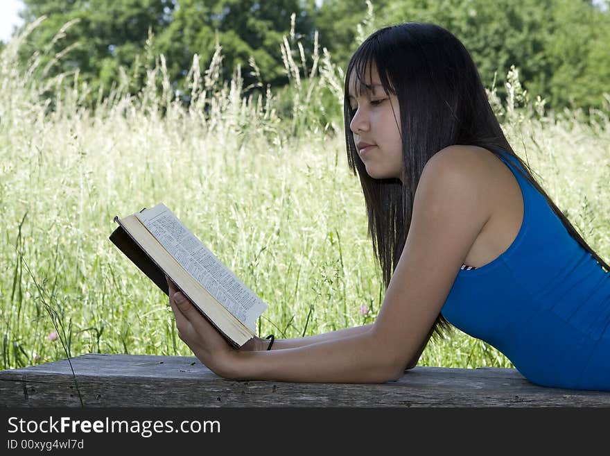 Teenager read a book in nature at an excursion