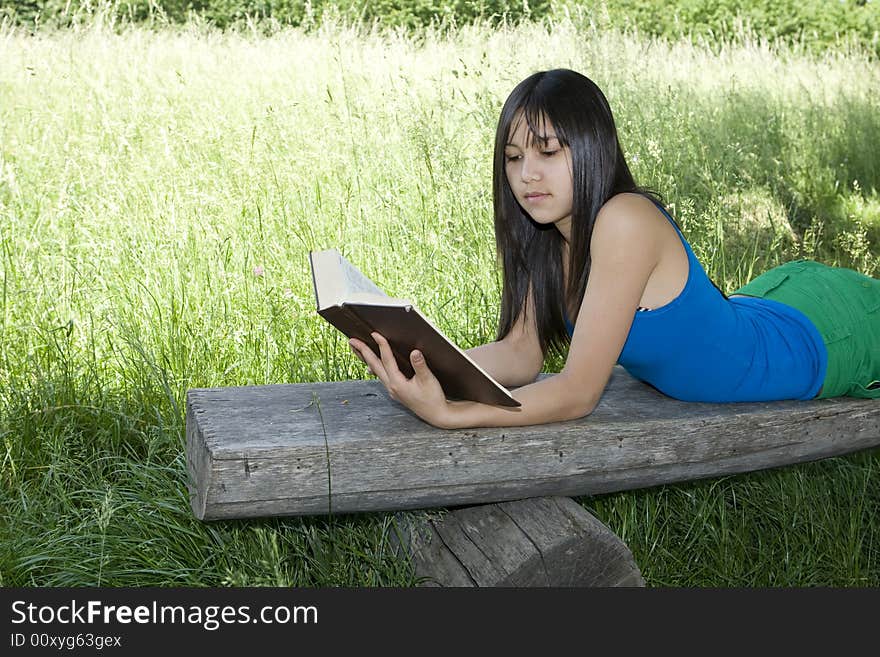 Teenager read a book in nature at an excursion