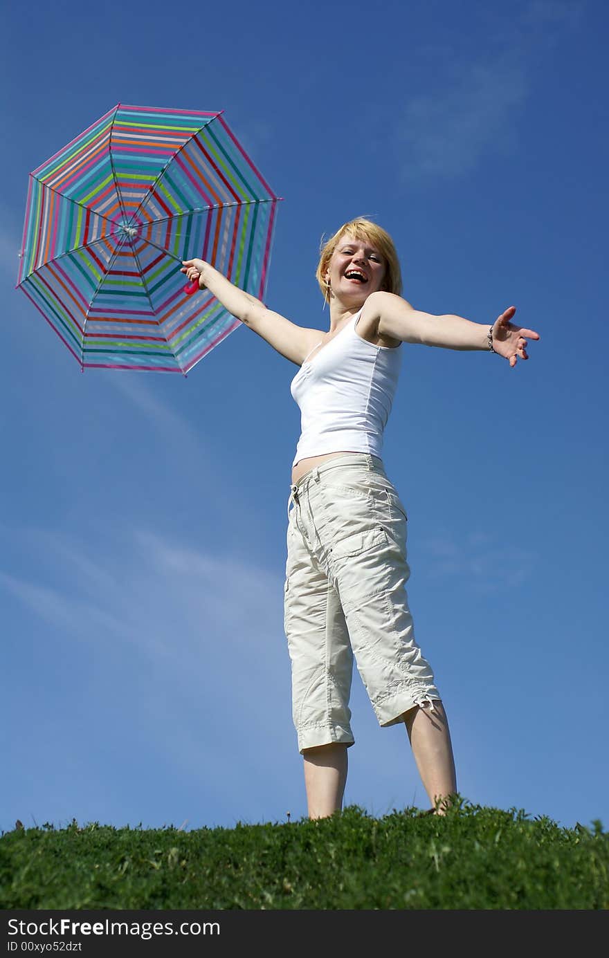 Yong charming girl with umbrella against blue sky