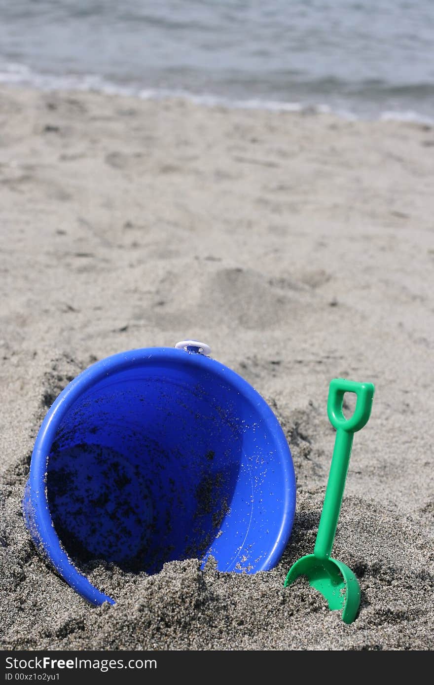 Blue Bucket on beach sand in northwest washington water