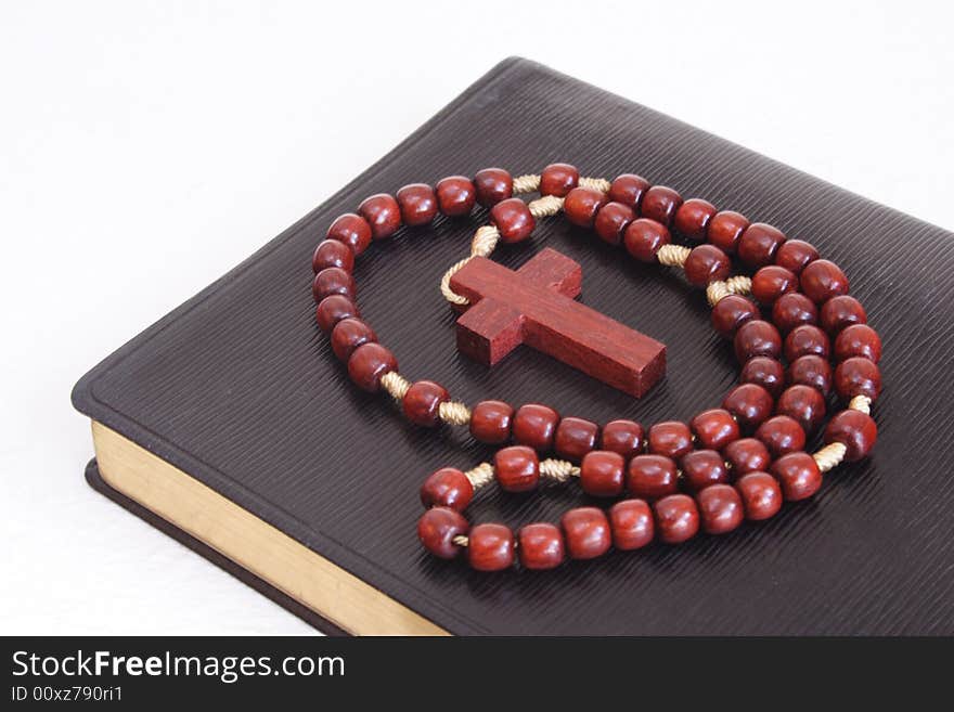 Rosary over a religious book with white background