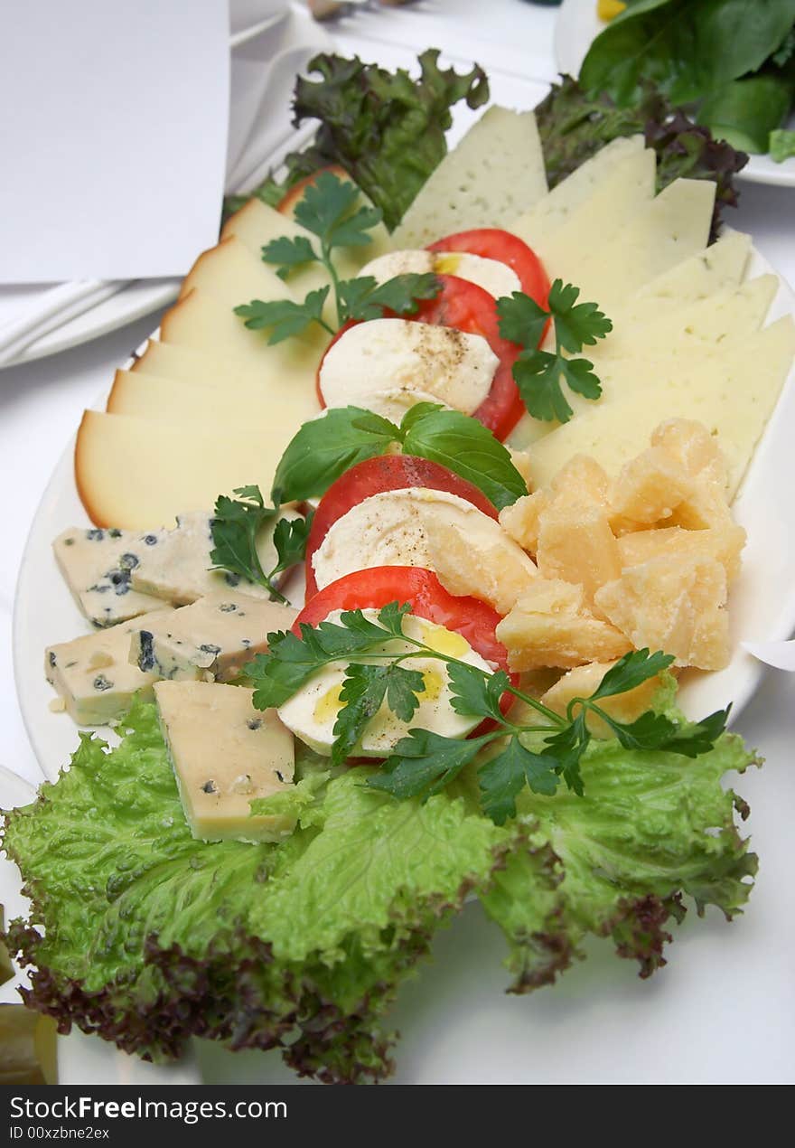 Plate with different kinds of cheese and a tomato