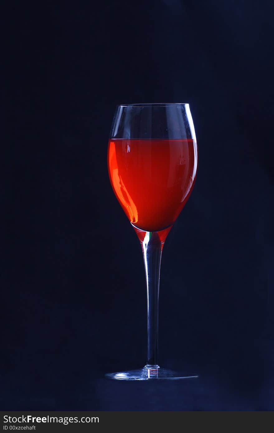 Backlit wineglass with red on black. Backlit wineglass with red on black