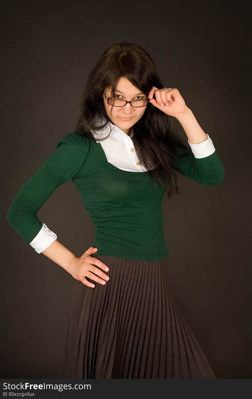 Serious looking girl in glasses isolated on black