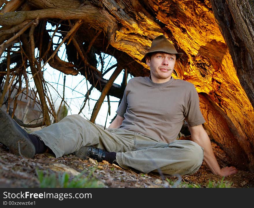 The man lays under an old tree