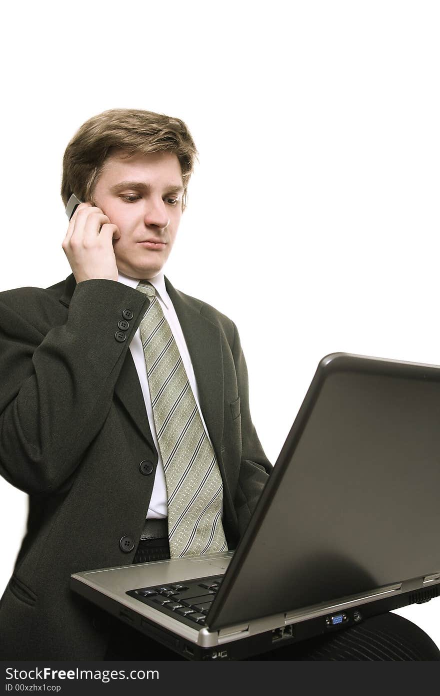 Young businessman working with laptop and cell phone