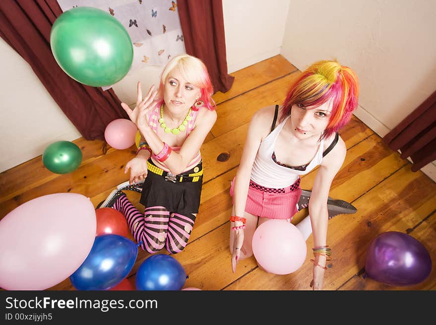 Two punk girls in a room with colorful balloons. Two punk girls in a room with colorful balloons