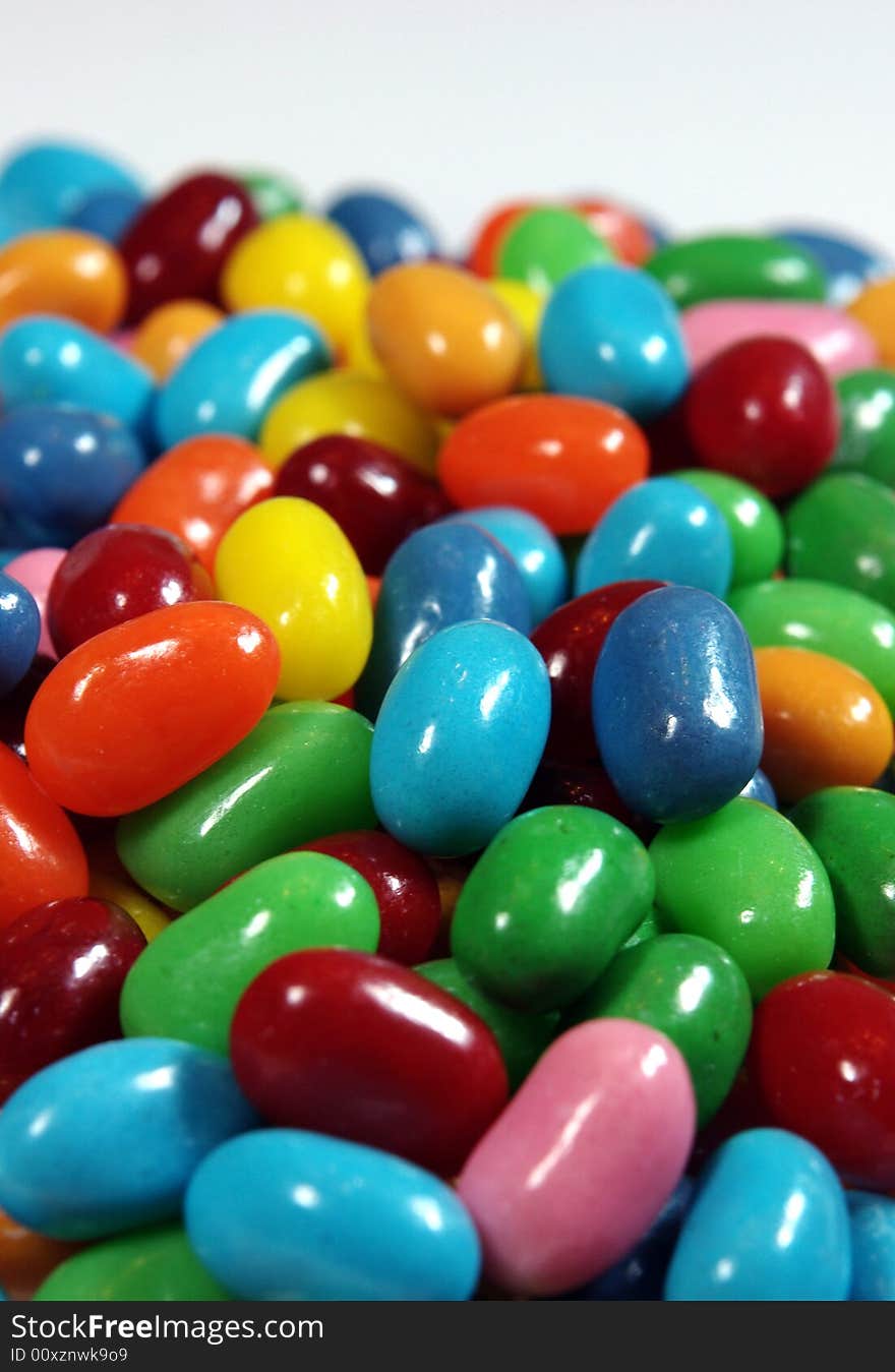 Multiple colored jelly beans on a light background.