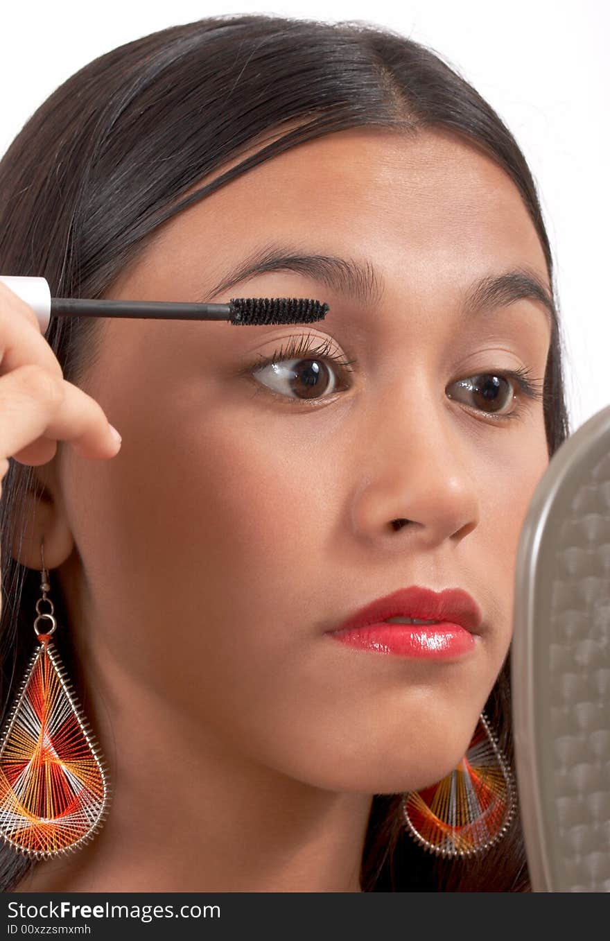 Pretty girl applying make-up on white background