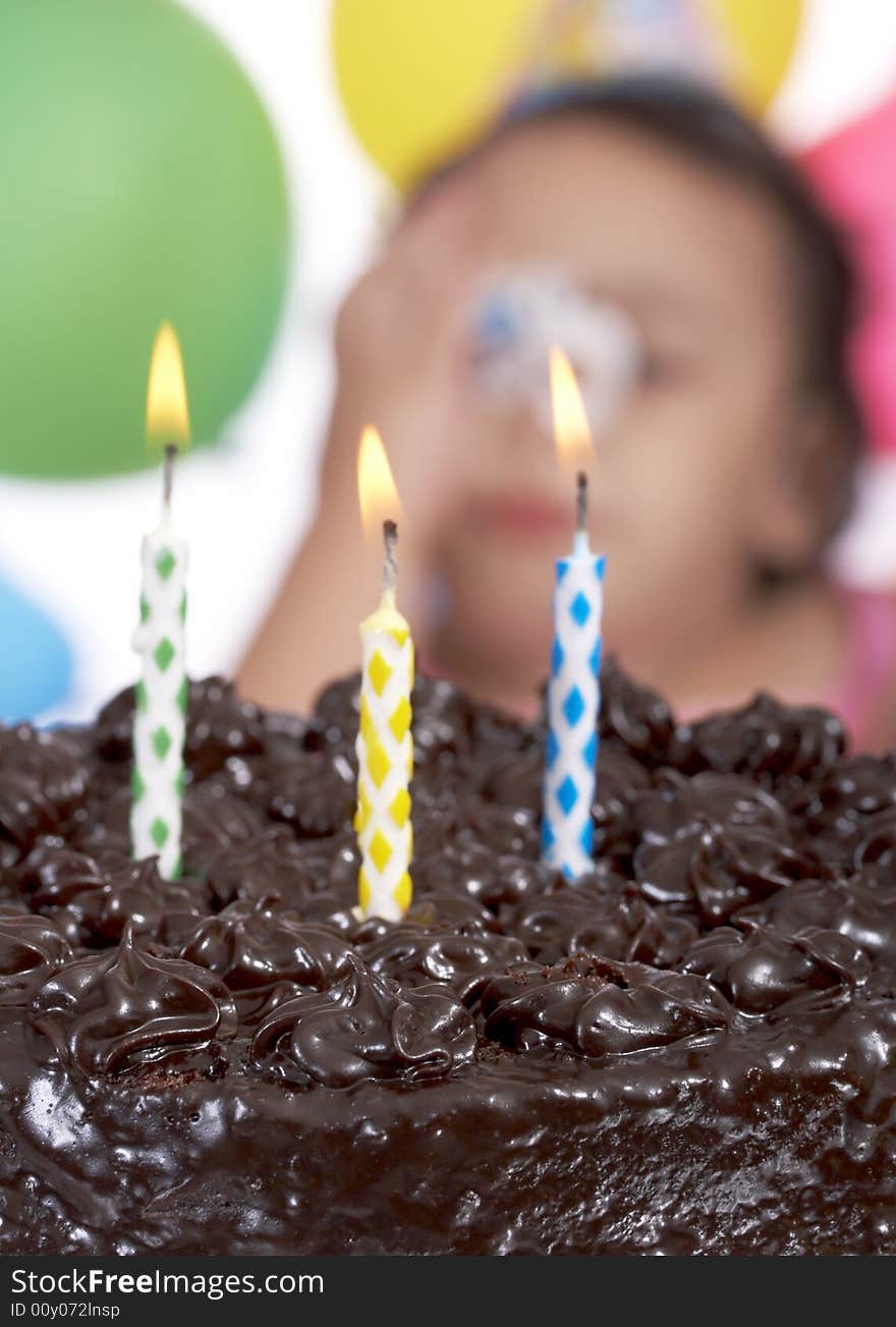 Three candle lights on a delicious chocolate cake