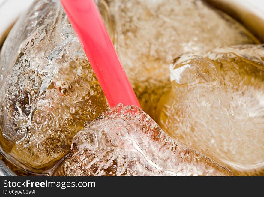 Cold fizzy cola with ice in a glass. Close up. Abstract background.