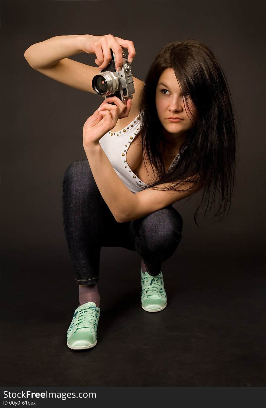 Young girl posing with retro camera isolated on black background. Young girl posing with retro camera isolated on black background